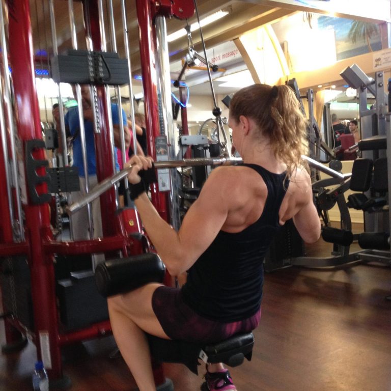 Christa traint met een kabelmachine in de sportschool.
