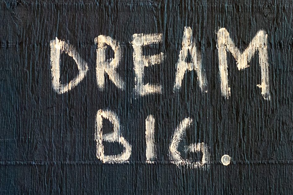 Een muur met de tekst "DREAM BIG." in grote, witte letters.