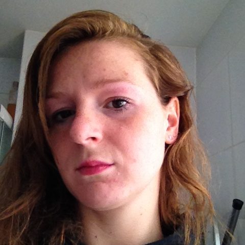 Portret van Christa met halflang haar, glimlachend in een binnenomgeving.