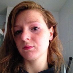 Portret van Christa met halflang haar, glimlachend in een binnenomgeving.