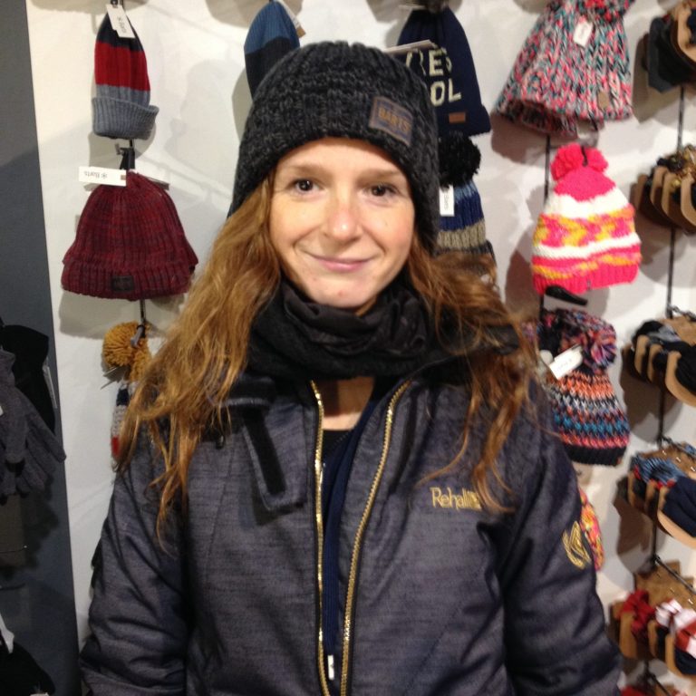 Christa in een warme jas en muts, omringd door winteraccessoires.