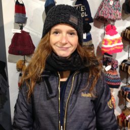 Christa in een warme jas en muts, omringd door winteraccessoires.